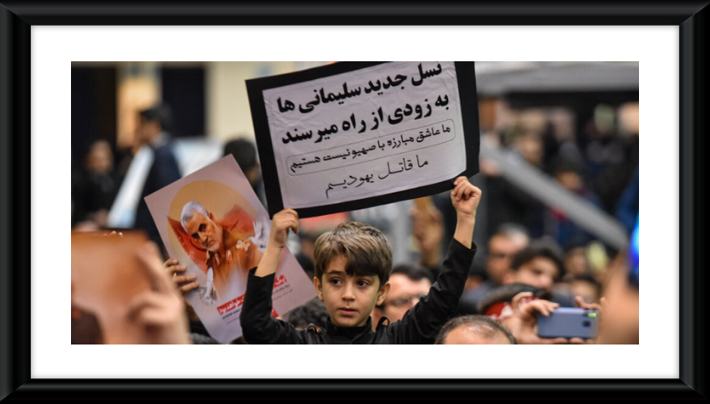 A boy holding a paper stating "we are the killers of the Jews" in the mourning ceremony for Qasem Soleimani at Mosalla of Tehran, 6 January 2020-WIKIPEDIA